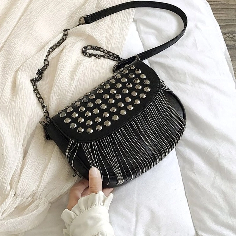 Schwarze gotische Nieten-Schultertasche flache seitliche Ansicht zeigt weiche Lederstruktur und Quasten-Akzente mit Verzierungen der Gothic-Umhängetasche