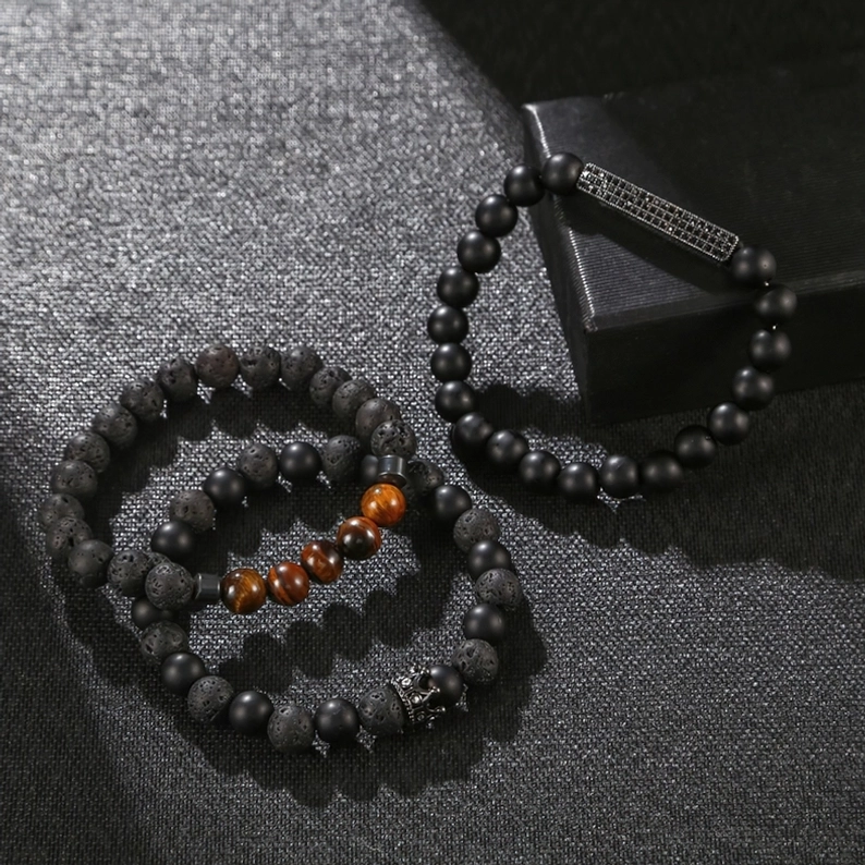 Unisex schwarzes Onyx Perlen-Armband in Luxus-Schmuckbox präsentiert, gravierte Metallakzente und Kronendekoration sichtbar, Flatlay-Styling zeigt Verpackungs-Hochwertigkeit