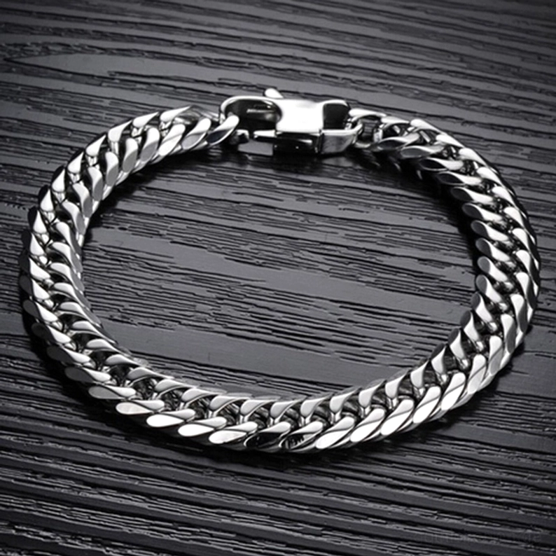 Draufsicht des geschlossenen Edelstahl-Gothic-Panzerarmbands auf dunklem Holzuntergrund mit vollständigem Kettendesign sichtbar
