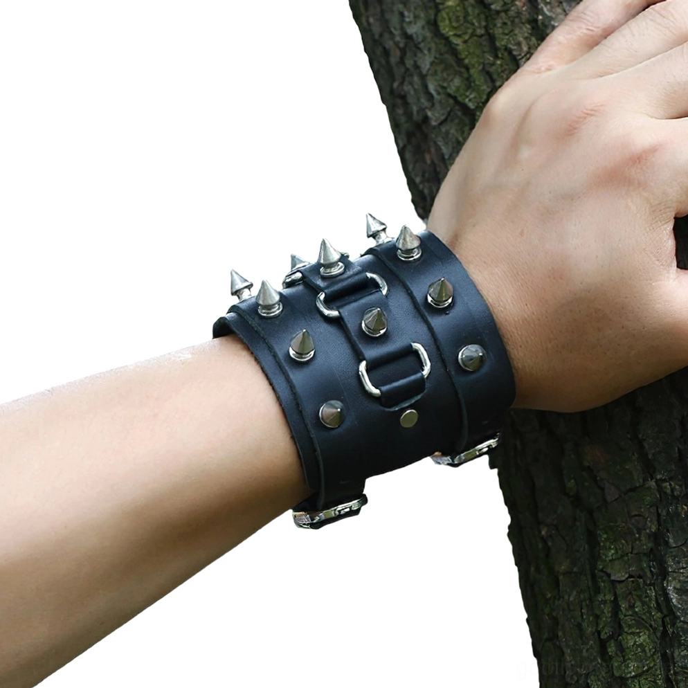 Getragenes gespikeltes Lederarmband am Handgelenk in Nahaufnahme, zeigt Punk-Gothic-Stil mit Naturhintergrund, reale Tragedarstellung des Armbands