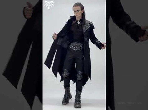 Männliches Model trägt schwarzen Gothic-Trenchcoat in Innenraum-Beleuchtung, zeigt dramatische Drapierung und Punk-Ästhetik mit Taillengurt-Detail