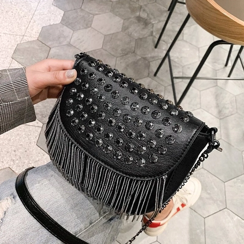 Gotische Quasten-Schultertasche Dreiviertelseitenwinkel zeigt Nieten-verzierte Lasche und Kettenquasten-Besatz Hardware der schwarzen Gothic-Umhängetasche