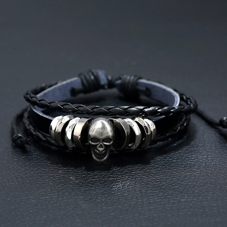 Vorderansicht Winkel des mehrschichtigen Leder Schädel Armbands zeigt geflochtene Riemen und silberne Zinklegierungs-Schädelanhänger mit Metallperlen Details