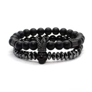 Schwarzes duales Gothic Schädel und Krone Charm Armband Set mit matter Steinperlen und Metallakzenten in Draufsicht Flat-Lay
