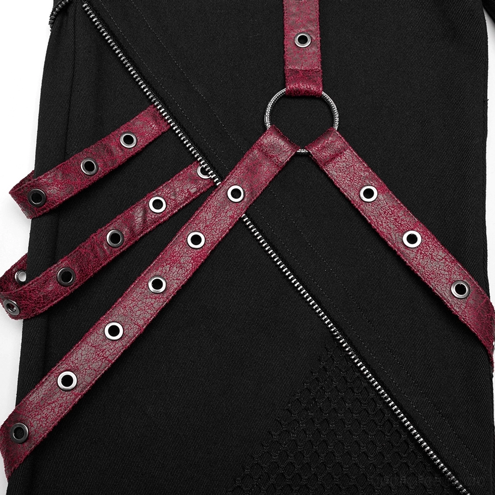 Makro-Nahaufnahme der Metal D-Ringe und gekrackelte weinrote Kunstleder-Harness-Riemen auf der schwarzen Gothic Schlaghose mit Rivet-Details