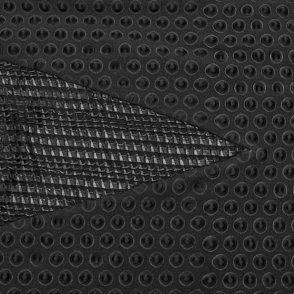 Vergrößerte Ansicht der perforierten kreisförmigen Mesh-Textur und gewobenen Akzent-Panel auf schwarzem Gothic-Tactical-Shirt-Stoff