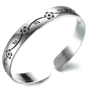 Gotisches Silber-Armband mit dunklen Blütenranken-Gravuren, schräge Seitenansicht mit antiker Patina-Effekt, oxidiertes Manschetten-Design