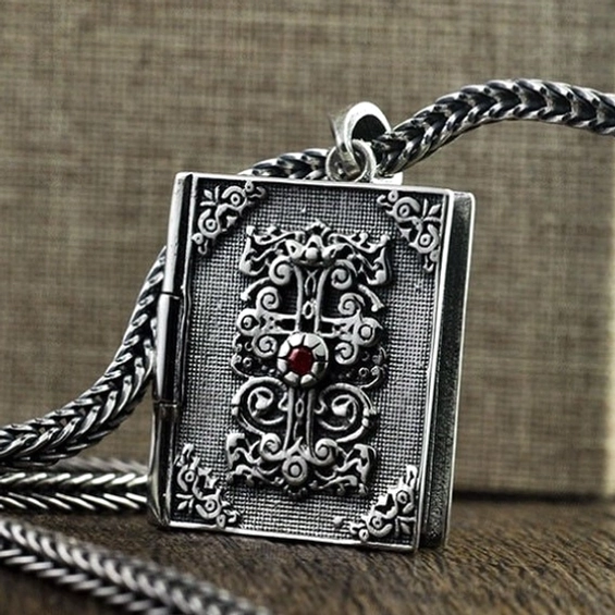 Sterling-Silber-Bibel-Medaillon-Anhänger auf gedrehter Silberkette mit Rubin-Farbton-Kreuz-Akzent, gotische Halskette Tragedarstellung auf Holzhintergrund