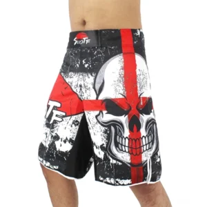 Vorderansicht von links zeigt schwarze Gothic-Kurzhose mit rotem Totenkopf-Kreuz-Print und Distressed-Textur getragen von männlichem Modell, lockerer Kampfsport-Shorts-Schnitt