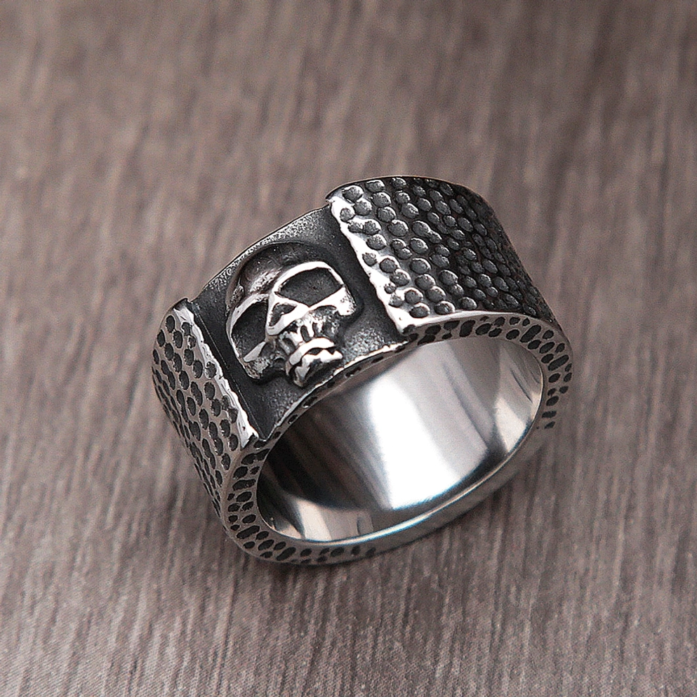 Cross-eyed skull gothic ring top oblique view showing hammered dot pattern metalwork surface detail and embossed skull design