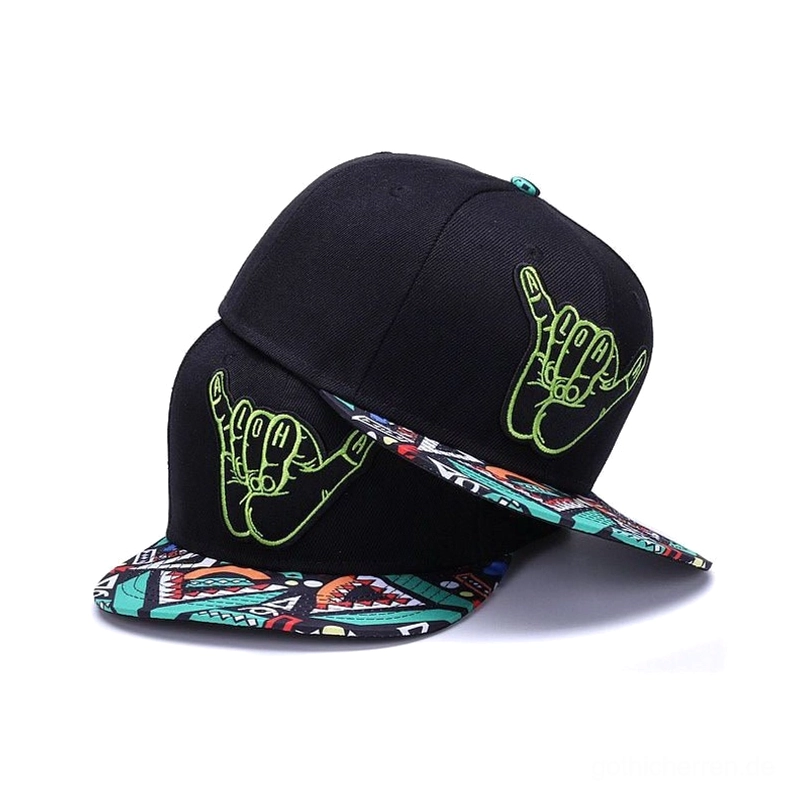 Gothic schwarze Snapback Cap mit neongrüner hand-bestickter Shaka-Hand-Logo und geometrisch gemustertem Schirm, schrägansicht von zwei übereinander gestapelten Kappen im Studio-Hintergrund