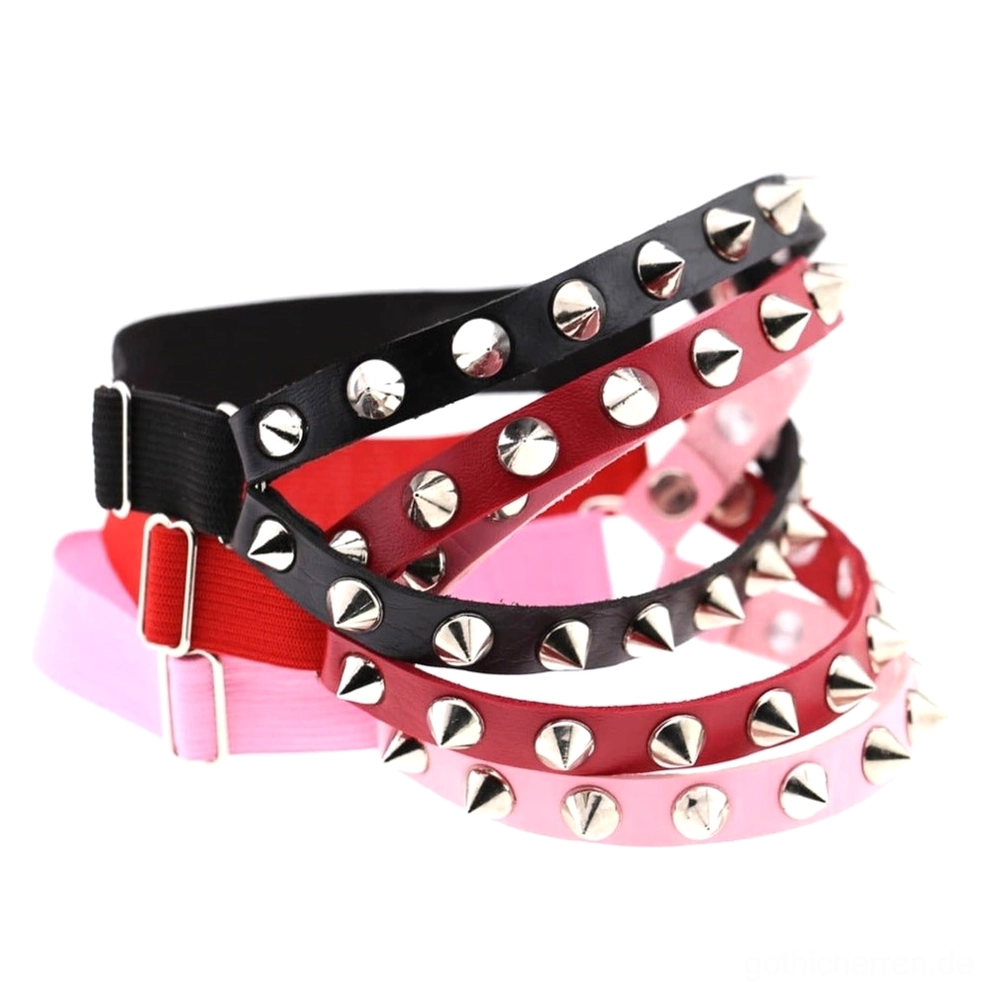 Mehrere verstellbare Gothic Spiked Knee Garter Belts in Flatlay-Display, Schwarz Rot und Pink mit silbernen Kegelnieten und Zinklegierungs-Studs, authentisches Leder-Harness für Goth-Ästhetik