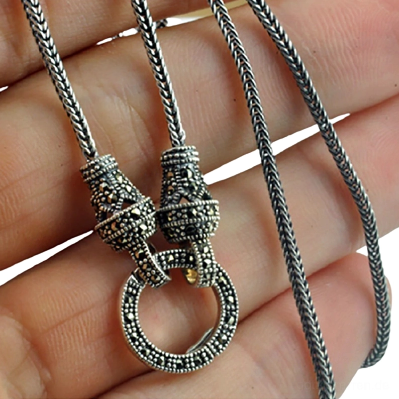 Antike Sterlingsilber-Halskette mit graviertem Markasit-Verschluss in Hand gehalten, Nahaufnahme der oxidierten dunklen Silber-Patina, Gothic-Schmuck Detail