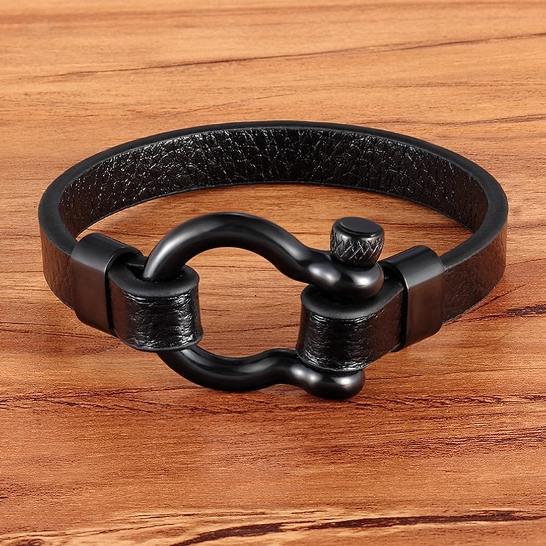 Tiefschwarzes mattschwarz Gothic-Toggle-Lederarmband auf Holzuntergrund - authentische Dunkelheit Ästhetik mit Patina-Charakter