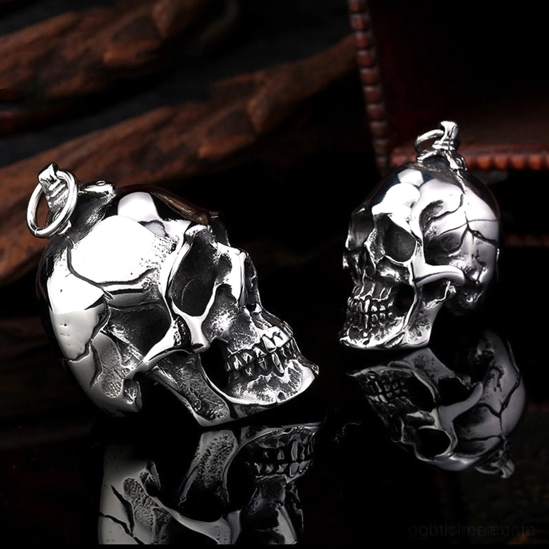 Rückseite doppelter Totenkopf-Anhänger mit präziser Schnitzerei und anatomischen Details auf reflektierendem schwarzem Hintergrund