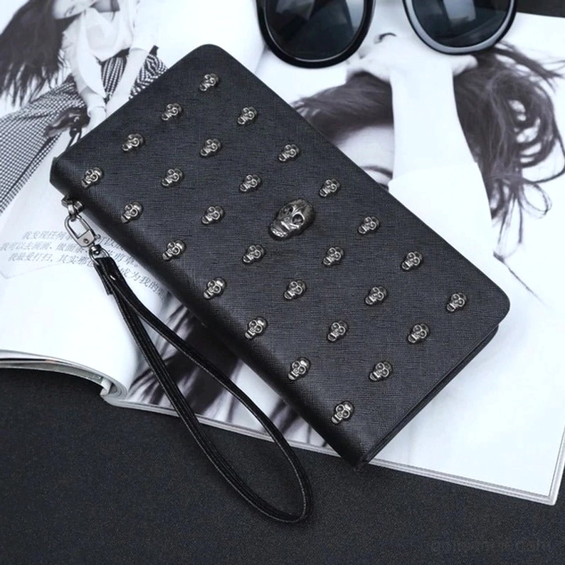 Gothic Totenkopf-Geldbörse Lifestyle Styling auf Modemagazin – mattschwarz PU-Leder mit Silber-Nieten und abnehmbar Handgelenkband Fashion Editorial Ansicht