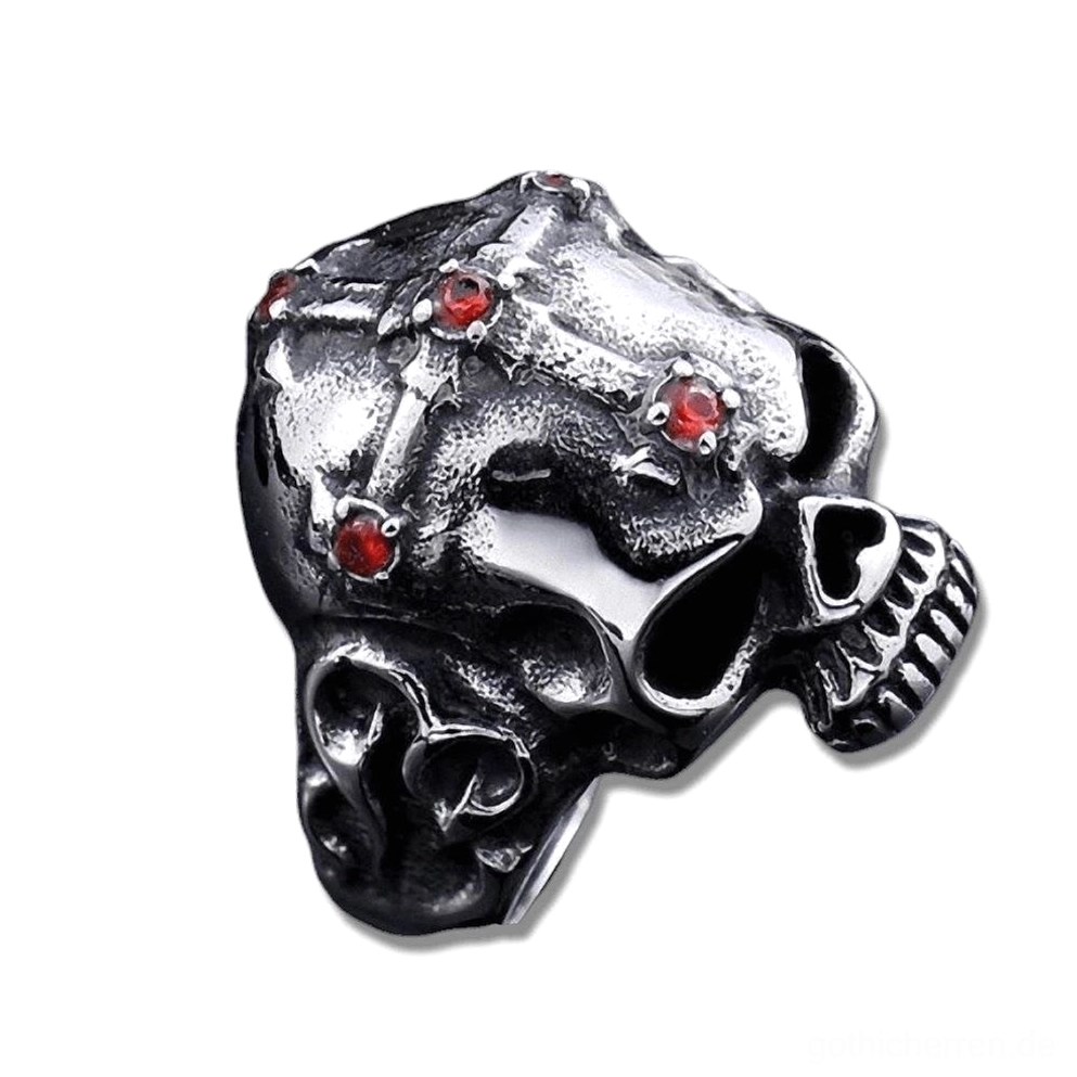 Geschwärzter gotischer Totenkopf-Ring mit tiefrotem Edelsteinakzent, Seitendreiviertelsicht mit intricate Kreuzspange und gemeißelten Kiefern-Details, Gothic Skull Ring Variante mit rotem Stein