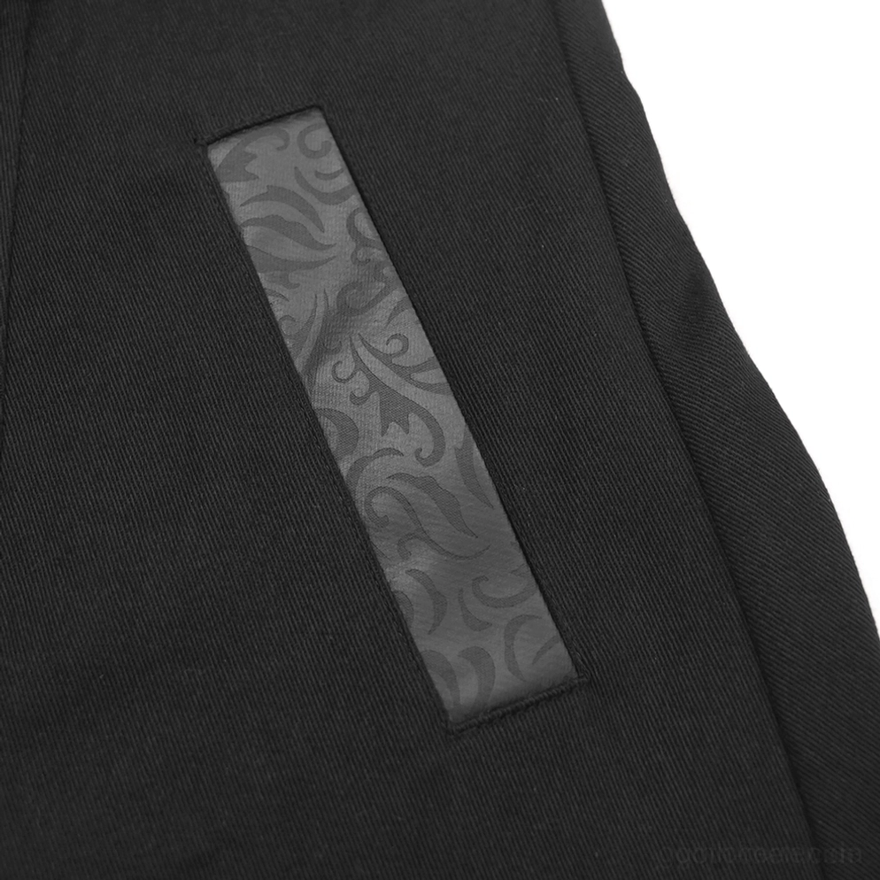 Nahaufnahme der Stofftextur vom schwarzen Gothic-Trenchcoat, zeigt schwarze Baumwoll-Basis mit geprägtem Damask-Kunstlederpatch-Muster