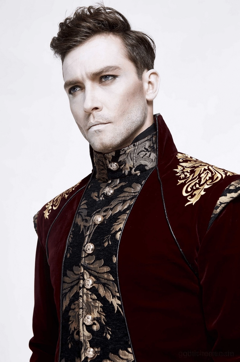 Nahaufnahme weindunkler Gothic-Gehrock Schulter und Brust mit ornamentaler Goldbrokade und hochstehendem Kragen Detail elegant