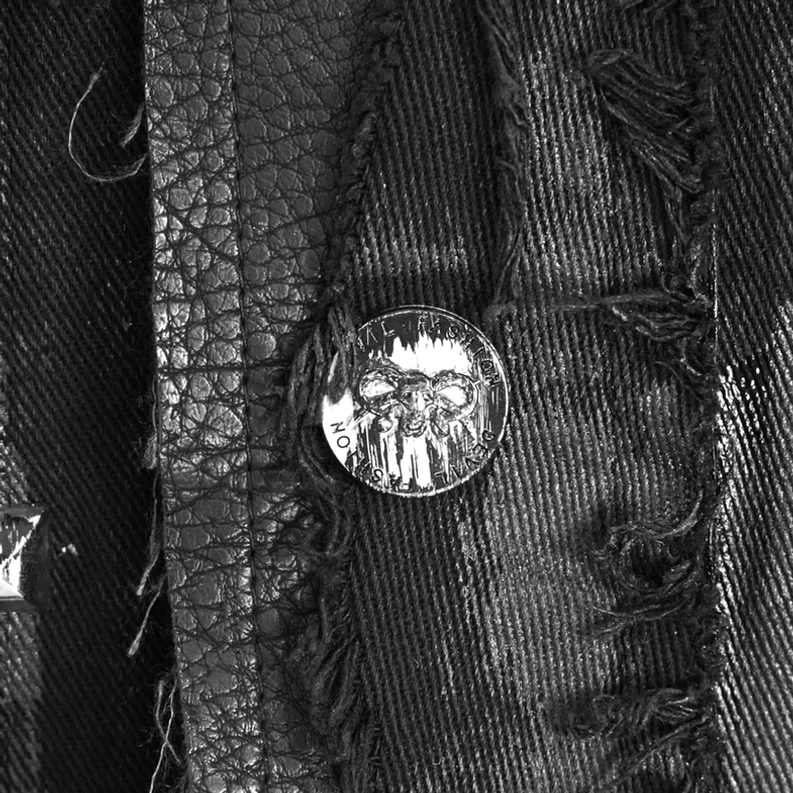 Nahaufnahme schwarze Gothic Weste Frontplakette zeigt Totenkopf geprägte Metallschnäpper Button frayed Denim und Lederimitat Textur