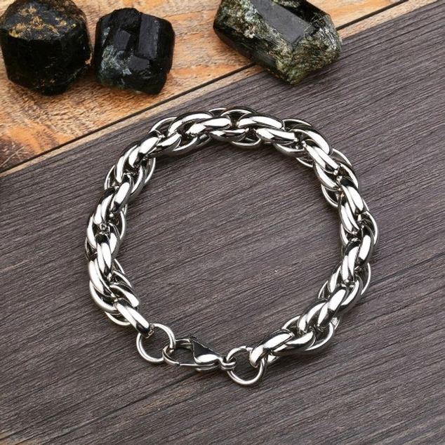 Einzelnes dickes Twisted-Ketten-Gotik-Armband Flachlage auf dunkler Holzoberfläche, silberner Edelstahl mit industriellem Design und sichtbarem Karabinerverschluss, Hauptansicht