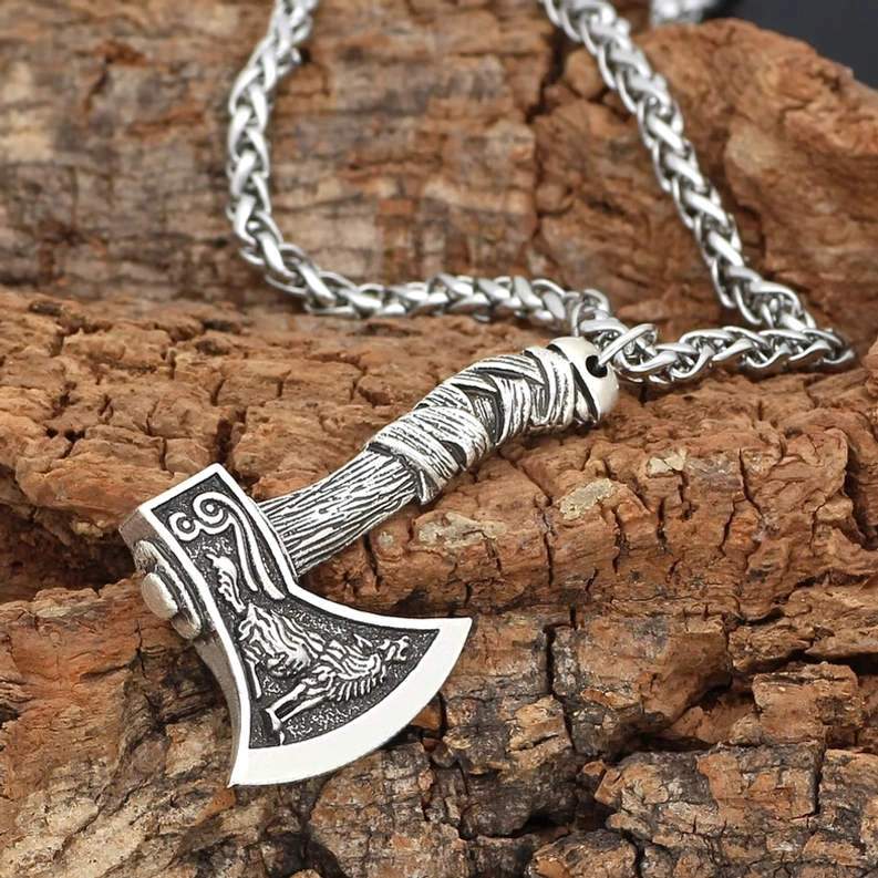 Antik-silberner gotischer Viking-Axt-Halskette mit Wolfschnitzerei und Weizengliederkette, Draufsicht Flat Lay auf strukturierter Rinde