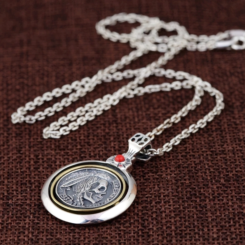 Totenkopf-Halskette Flat-Lay mit doppelseitigem Münz-Anhänger an Weizenglied-Sterlingsilber-Kette auf braunem gewebtem Stoff, gotisches Schmuck-Styling für Alltagstragen und Mode