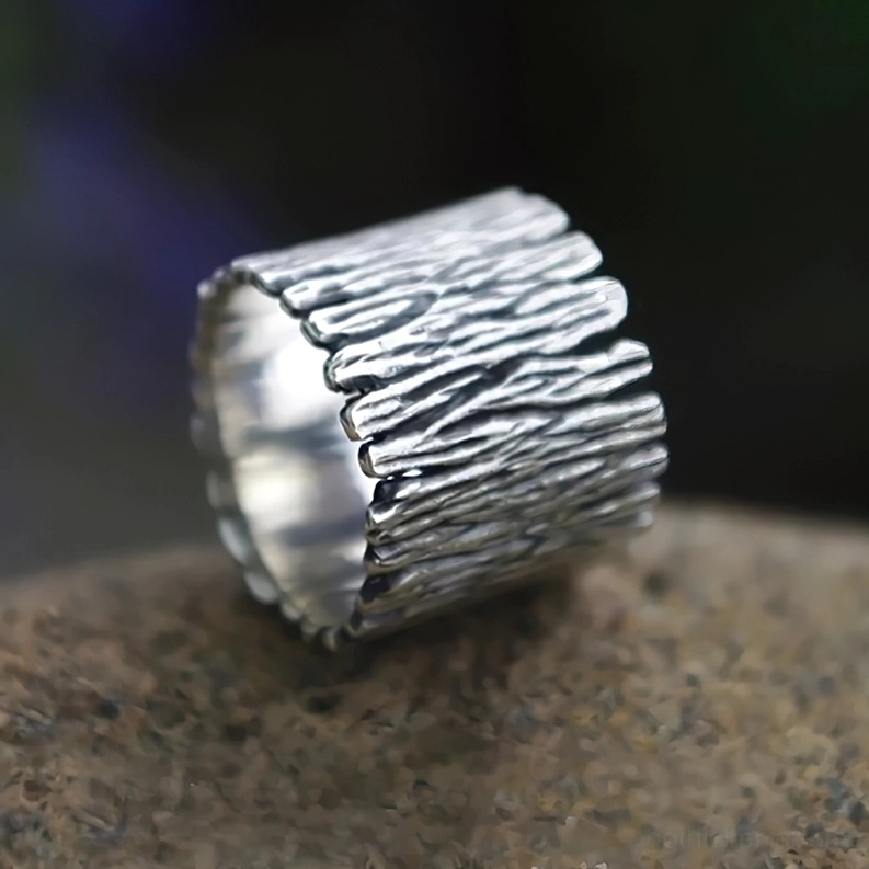 Seitenprofil des Wikinger-Runen-Rings auf Steinoberfläche zeigt Holzmaserungstextur, Ringöffnung mit Kerbung und polierte innere Wanddetails des Talismans
