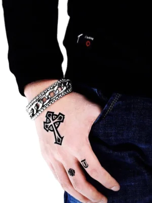 Doppelschicht-Edelstahl-Gotik-Armband für Herren am tätowierten Handgelenk getragen, Seitenansicht Nahaufnahme mit industriellem Punk-Design und silberpolierter Oberfläche, Twisted-Curb-Kettenglieder