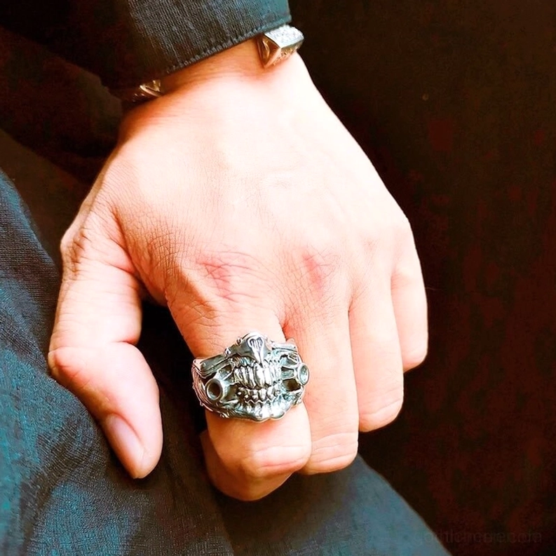 Seitliche Handansicht des Totenkopf-Panzerrings – zeigt detailliertes gotisches Design mit Hohlportalen und Rüstungsdetails, kombiniert mit Denim für Alltags-Look