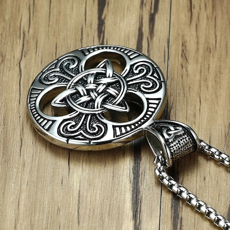 Keltischer Knot Pendant und abgelöste Kette Edelstahl Flatlay Holzuntergrund Kettenoptionen