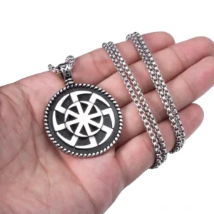 Kolovrat heidnisches Sonnenrad-Pendant in der Hand gehalten, zeigt Größenvergleich und vintage 316L Edelstahl-Material-Details des gothischen Schmucks