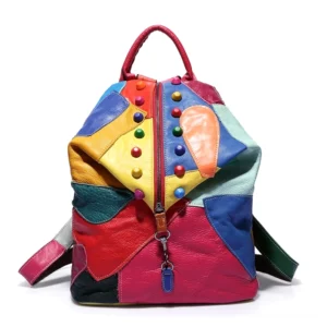Mehrfarbiger Patchwork Gothic Rucksack aus Leder mit bunten Nieten, pinkem Tragegriff und Reißverschluss in Vorderansicht