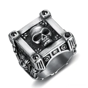 Gothic Totenkopf Signet Ring aus Edelstahl – schräge Draufsicht mit geometrischem Rahmen, schwarzen Diamant-Akzenten an den Ecken und feinen gravierten floralen Seitenmustern