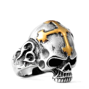 Silbertoniger Edelstahl-Totenkopf-Kreuz-Ring mit Goldakzenten, Vorderansicht mit detailliertem gemeißeltem Schädel und prominentem Kreuz oben, Gothic Ring für Herren mit hochpolierter Oberfläche