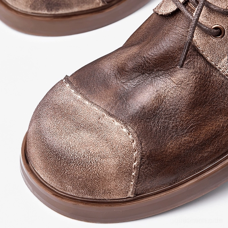 Men's dark distressed leather gothic boots lifestyle product shot in alternative fashion setting, perfect for goth aesthetic styling, underground culture and dark romantic wardrobe