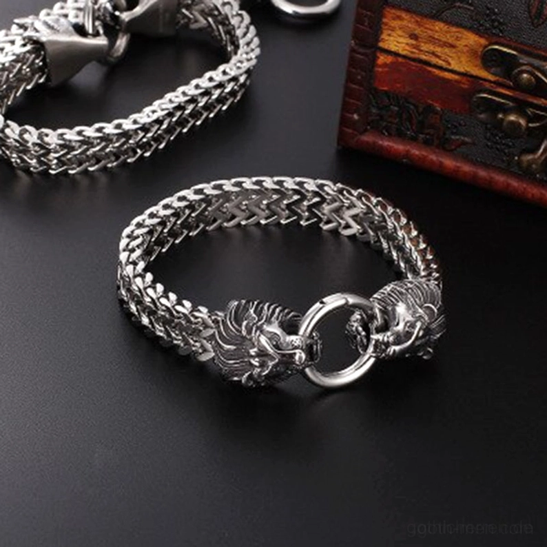 Mehrere gothische Löwenkopf Kettenarmbänder nebeneinander ausgestellt, polierter Edelstahl, vintage Holzhintergrund zur Sammlung von Punk-Statement-Schmuck