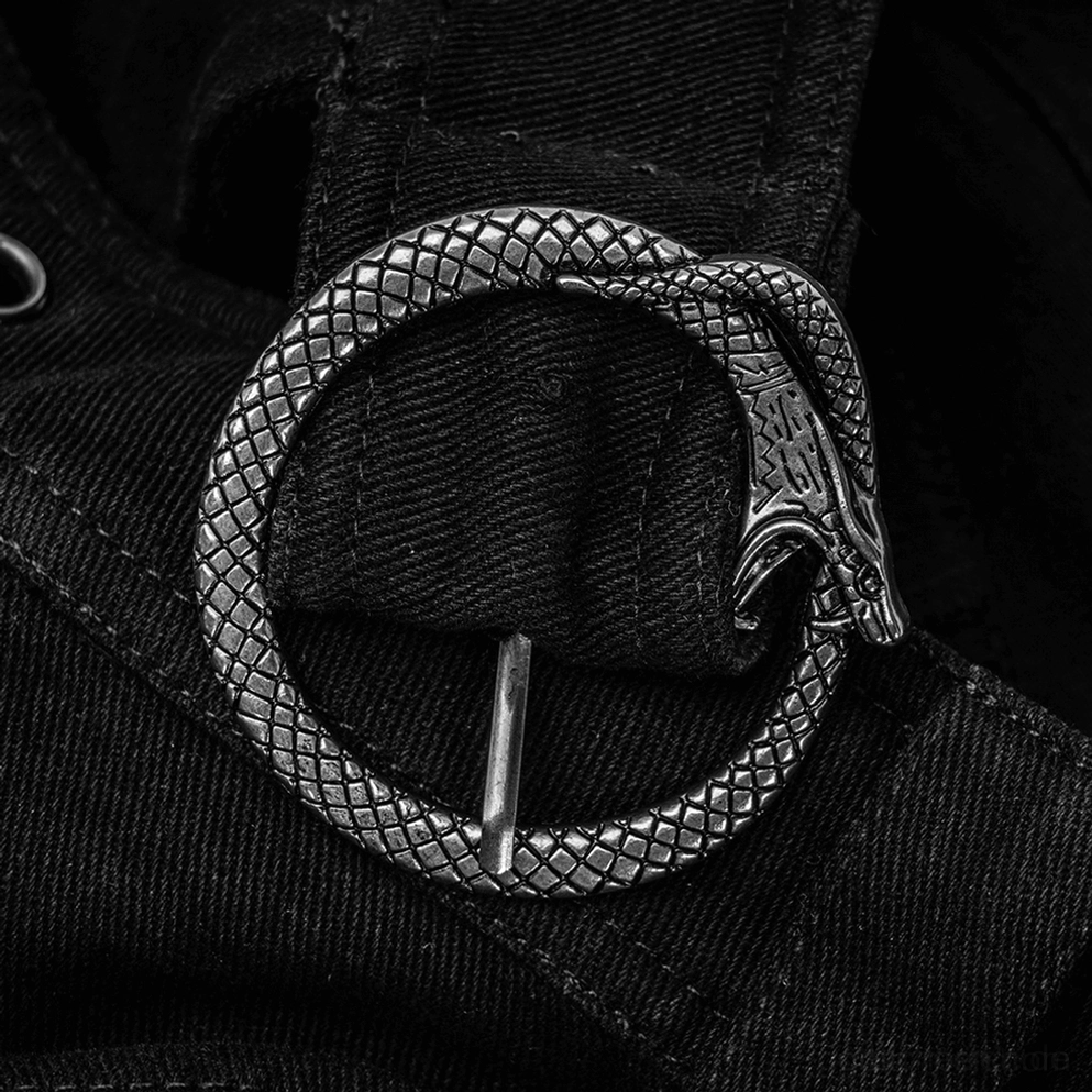 Makrofotografie der Ouroboros-Schlangen-Metallschnalle mit texturiertem silberfarbenen Finish auf schwarzem Gothic-Herrenrock, mythologisches Designelement