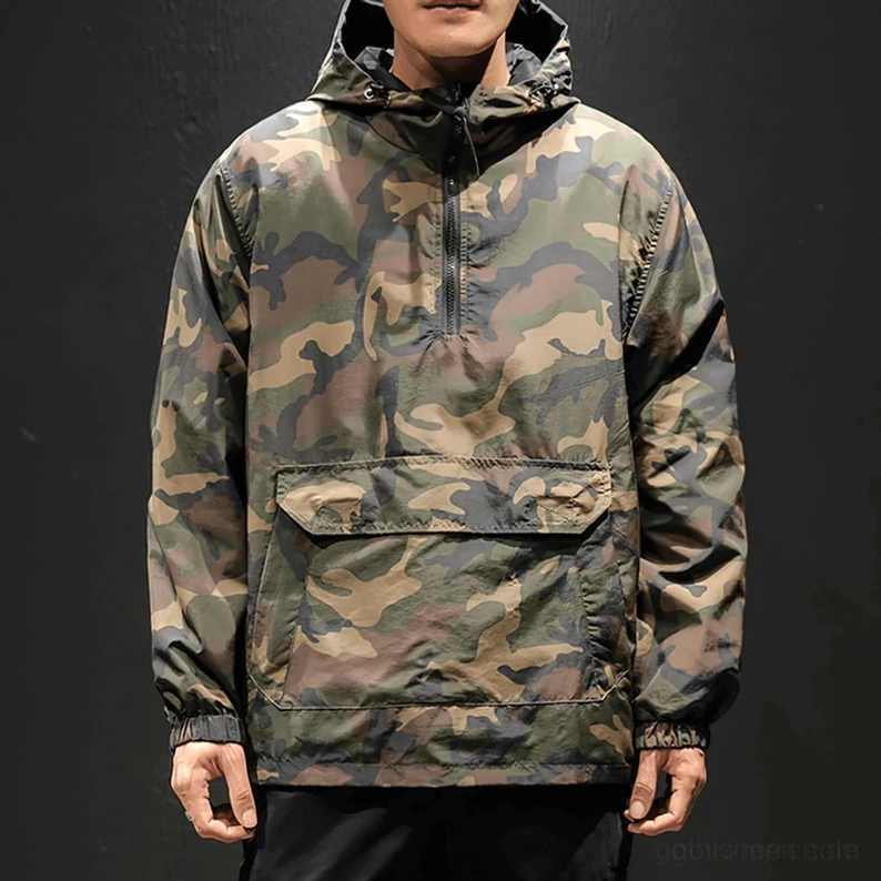 Vorderansicht des männlichen Modells im Oversized-Camouflage-Gothic-Kapuzenpullover, große Känguru-Tasche, Half-Zip-Design, mühelose Alternative-Ästhetik, dunkler Hintergrund