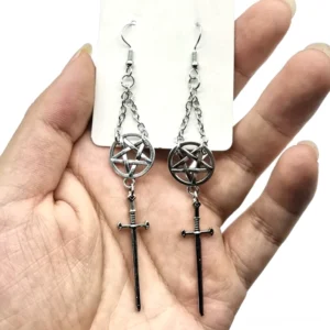 Silberne und schwarze Pentagramm-Schwert-Dangle-Ohrringe in der Hand gezeigt, asymmetrisches Gothic-Design mit Edelstahlketten und Charms, neogotisches Statement-Schmuck