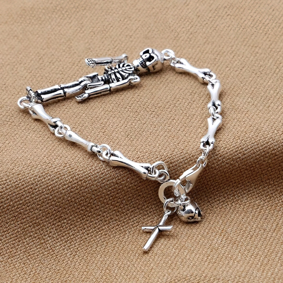 Vintage Skelett Silber Armband mit Kreuz-Charm auf neutralem Stoffhintergrund, zeigt Knochenketten-Glieder, Toggle-Verschluss und gotisches Design