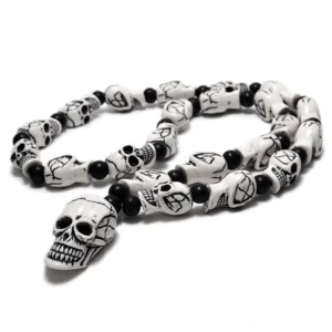 Retro-weiße gotische Totenkopf-Halskette mit gravierten Kreuzdetails und matten schwarzen Perlen – Draufsicht auf gotische Memento-Mori-Anhängerkette