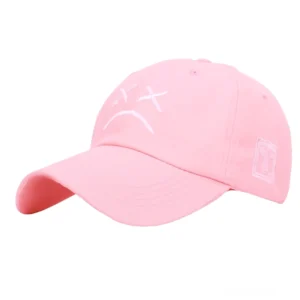 Rosa Soft-Goth Cap mit gesticktem emotionalen Trauer-Gesicht, Seitenwinkel Studio-Fotografie, Pastel-Alternative Fashion