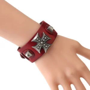Rotes gotisches Maltese-Cross-Lederarmband an Puppe getragen, Seitenansicht mit detailliertem Metallkreuz und verstellbarem Cuff-Design