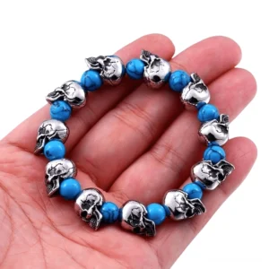 Gothic Schädel Armband an der Hand getragen, Nahaufnahme Detail zeigt Vintage-Silberfinish und blaue Perlen, Elastik Stretch Passform