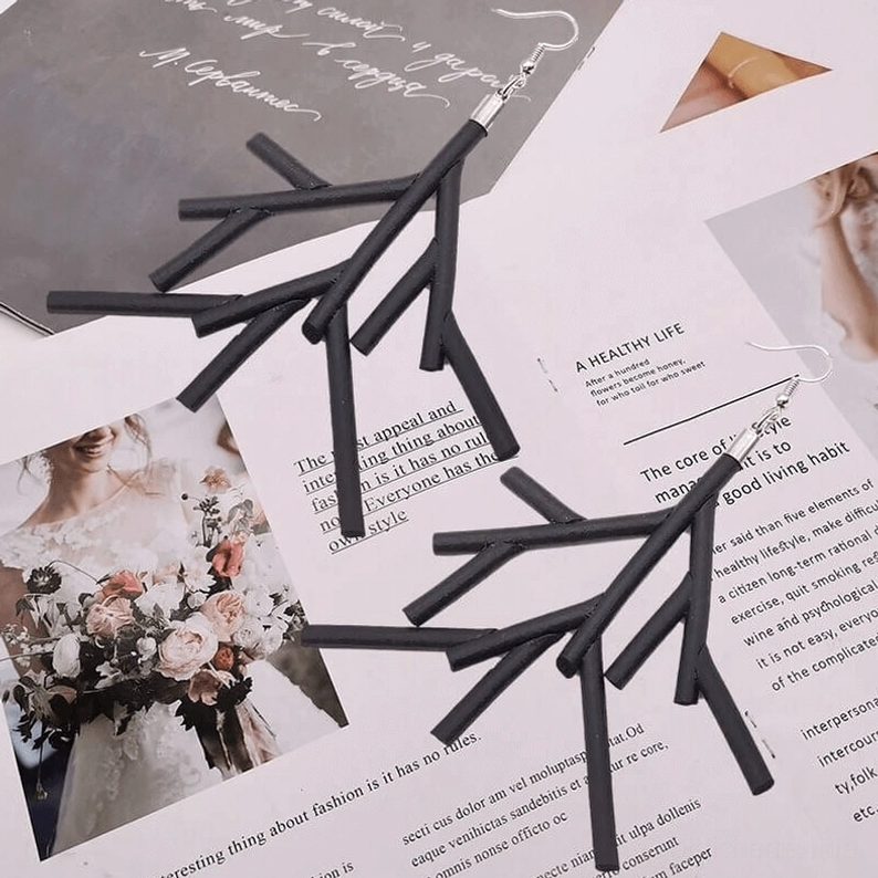 Zwei Paare schwarze Ast-Ohrringe Flat-Lay auf Lifestyle- und Fashion-Magazinseiten mit Hochzeits- und Blumenmotiven, minimalistische dunkle gotische Alternative-Schmuck