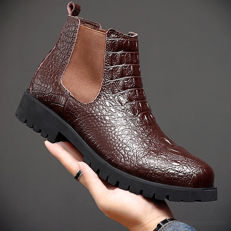 Detailnahaufnahme schwarzer gotischer Chelsea Ankle Boots mit Krokodil-Prägung, Lederstruktur und Handwerkskunst deutlich sichtbar, geprägte Textur-Oberfläche in Nahaufnahme