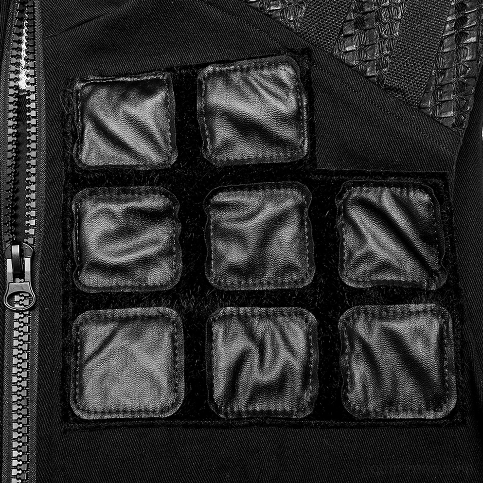 Nahaufnahme Detail schwarzer Denim Tactical Weste Vorderseite zeigt geometrische Kunstleder-Wattierungsflecken und Metallreißverschluss, Gothic Armor Konstruktion
