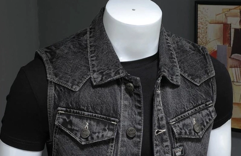 Nahaufnahme Vorderdetail der gotischen Denim-Weste zeigt spitzen Kragen, markierte Metallknöpfe und Brusttaschen-Konstruktion