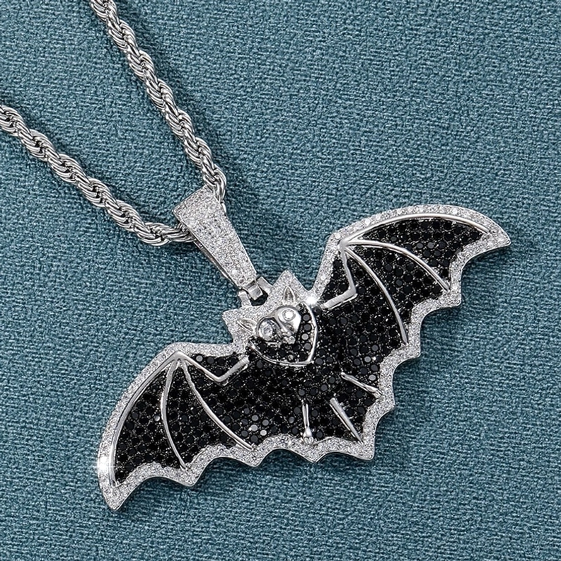 Gothic Fledermaus Silberhalskettenanhänger in 3/4-Ansicht auf Twisted Chain mit schwarzen Pavé kubischen Zirkonia Flügeldetails vor Teal-Hintergrund